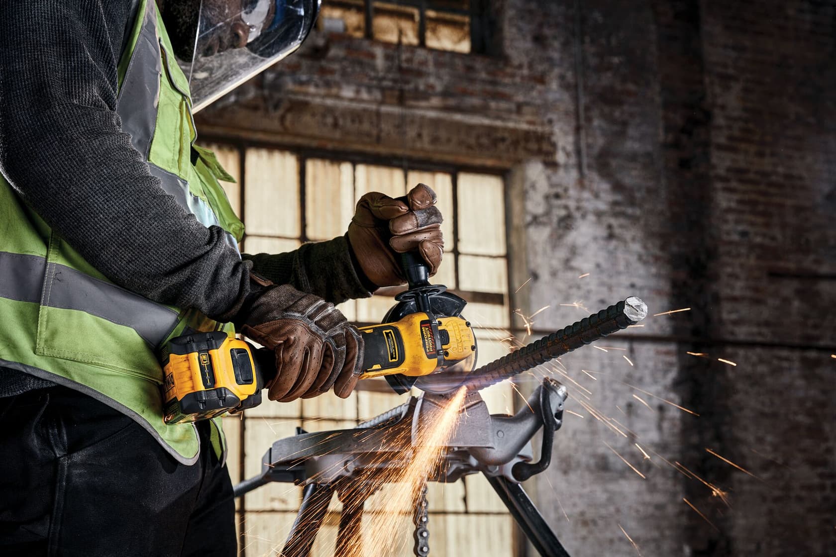 Brushless 18V XR 125mm cordless angle grinder being used to cut rebar in a workshop setting