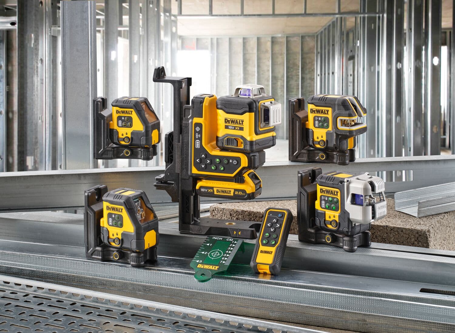 A collection of DEWALT laser levels and measuring tools displayed on a construction site, featuring metal framing in the background. The tools are yellow and black and are positioned on steel beams, with accessories including a remote control and laser target plate.